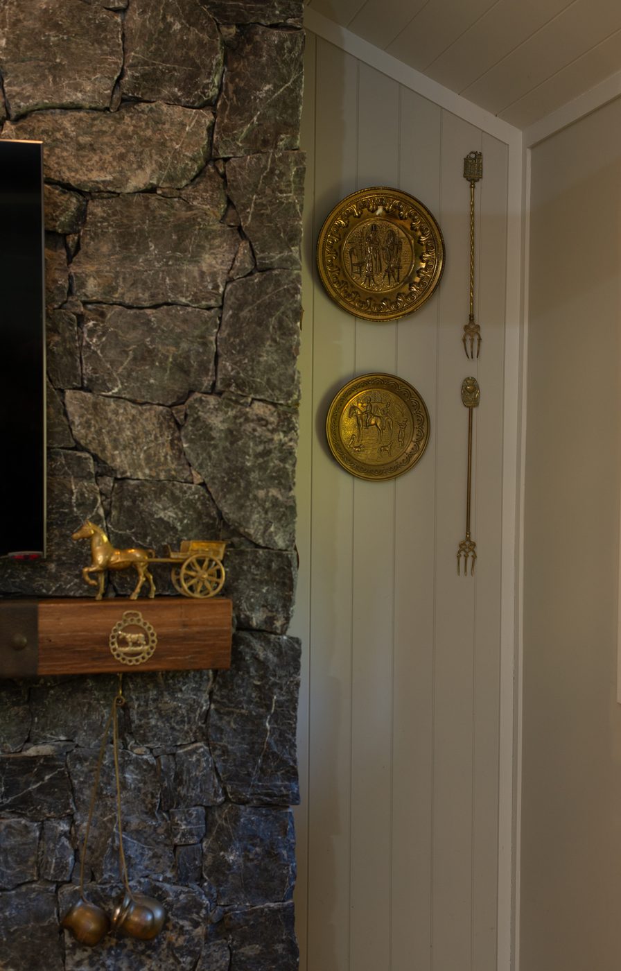 Antique horse brass and a brass horse-cart on the stone mantel